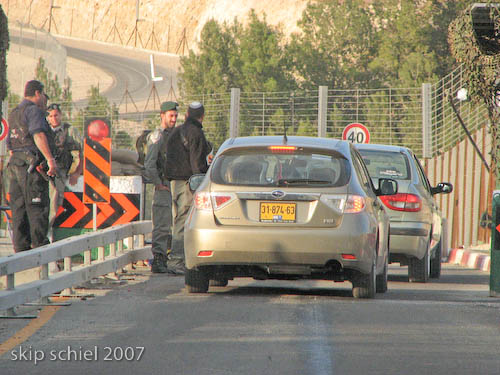 Vehicles with yellow Israeli plates pass freely on their way to settlements