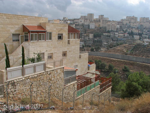 Settlement in foreground, Palestinian community in background, wall between